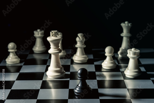 Chess board. Black checker threatens the white chess opponent