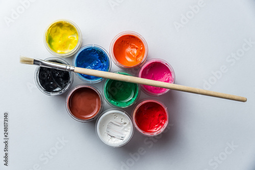 small cans with colorful gouache paints and tassels for the whole frame