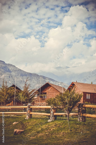 wooden houses in the valley between the mountains and the forest