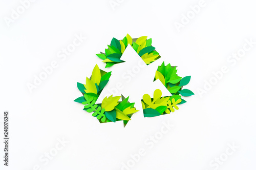 Green color recycling sign made from paper leaves. Cut tropics plant. photo