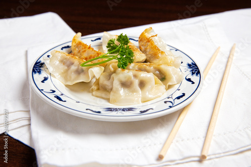 Chinese dumplings on a plate. Asian fried dumplings and chopsticks on a table