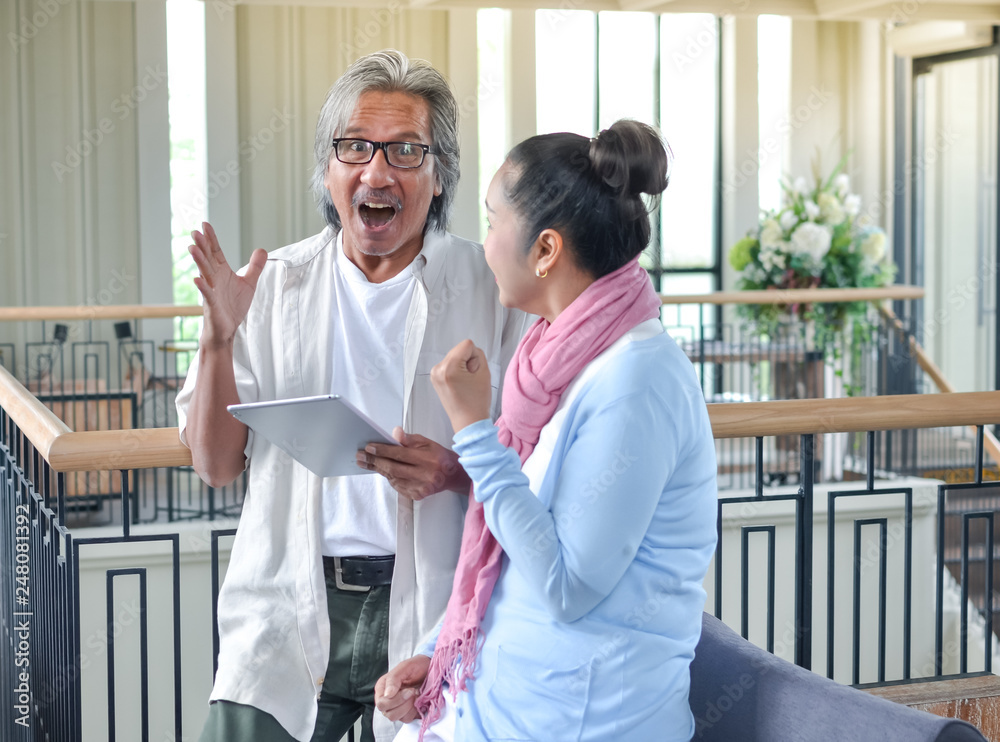 Fototapeta premium old age, technology and people concept - happy senior couple with tablet..asian elderly couple ues tablet