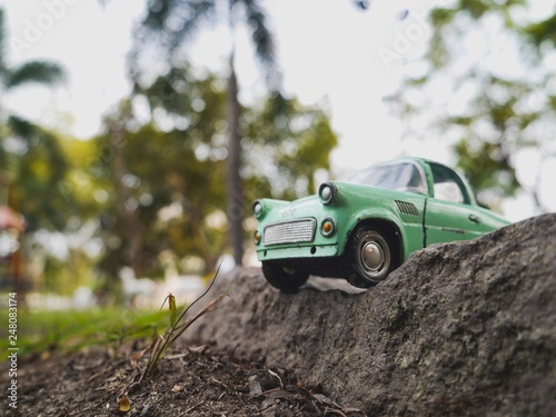 The green classic car toy on the ground in the health park