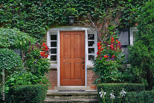 elegant wooden front door of vine covered house