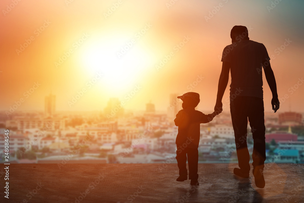 Child, baby holding an adult's hand. Father and son on a walk. Happy lovely baby on a wooden terrace with sun sets blurred. Little baby having fun time activity .silhouette concept.