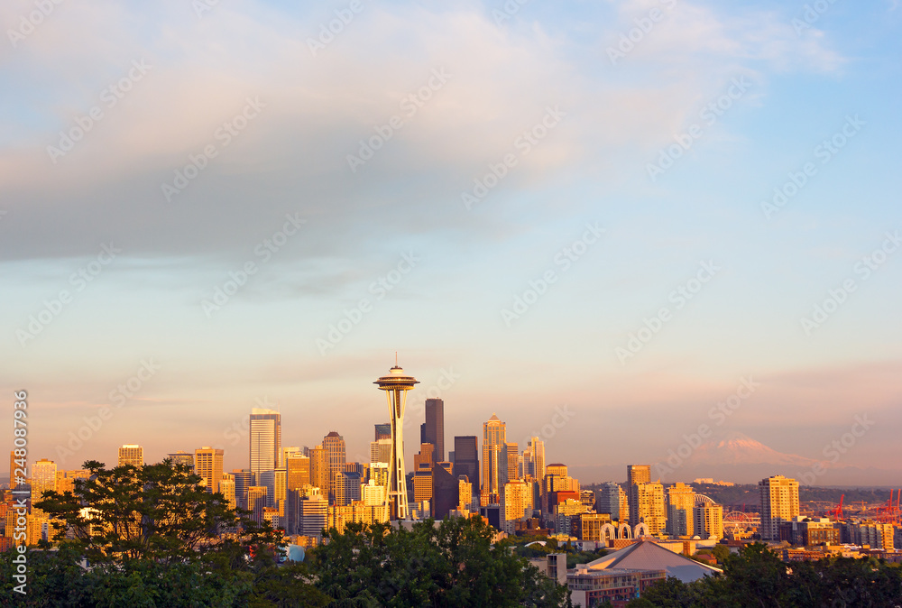 Seattle city landscape at sunset with Mount Rainier on horizon. City panorama and Mount Rainier snow top in clouds.