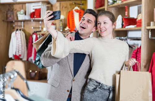 Young woman and man are taking selfie after shopping together