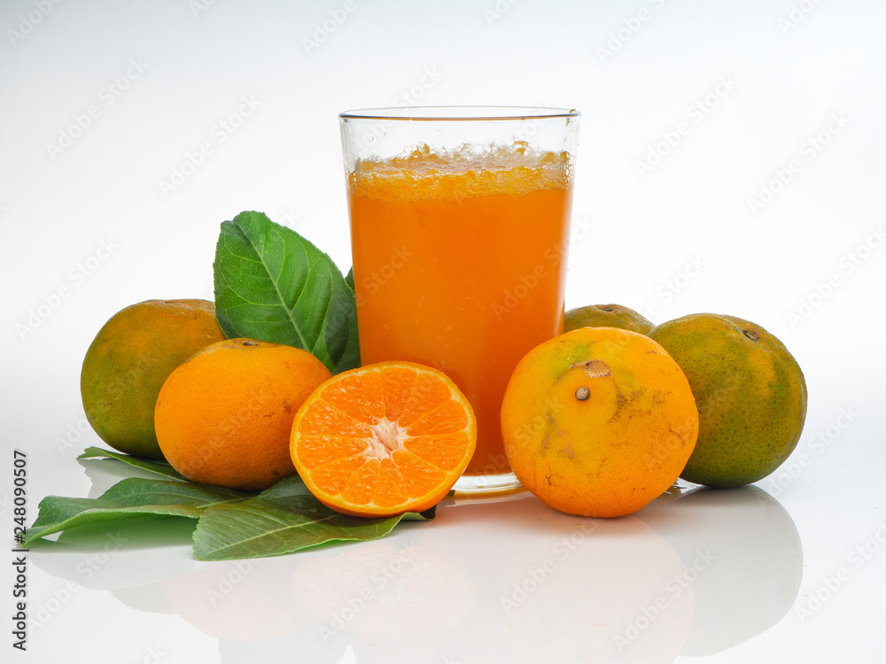 Glass with orange juice and fruits with green leaves Glass with orange juice and fruits with green leaves