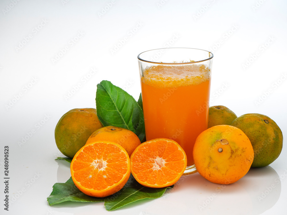 Glass with orange juice and fruits with green leaves Glass with orange juice and fruits with green leaves
