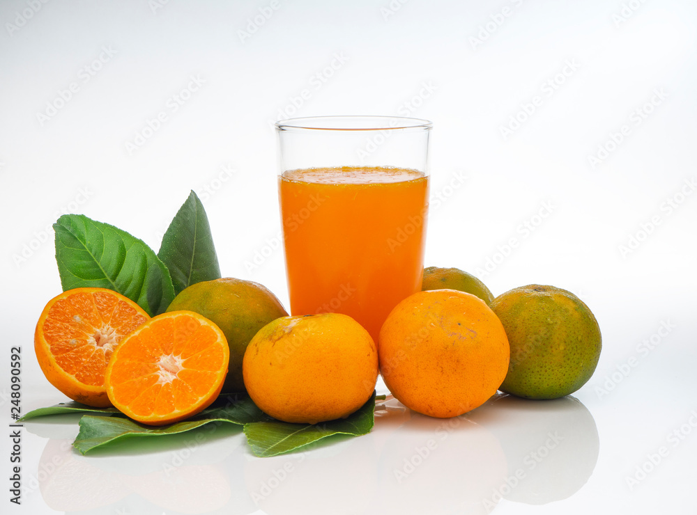 Glass with orange juice and fruits with green leaves Glass with orange juice and fruits with green leaves