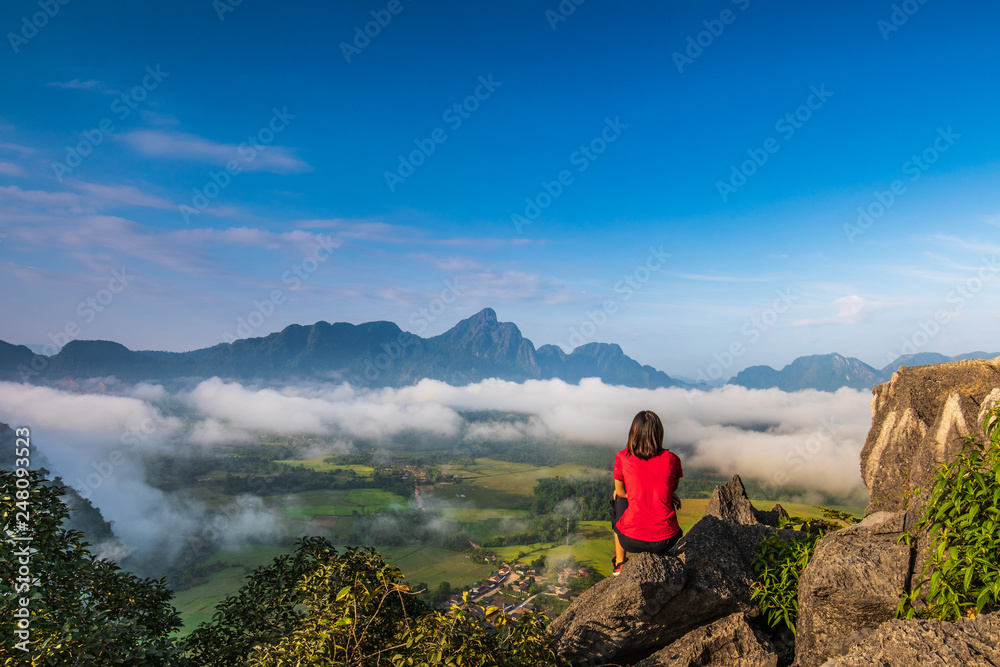 Fototapeta premium Young girl travels on high mountain in Vang-Vieng, Laos.