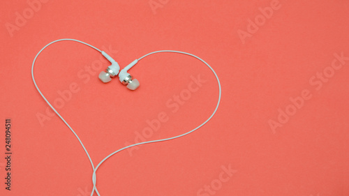 Beautiful modern, digital ,plastic ,vacuum, white headphones with wires for listening to music on a purple pink background