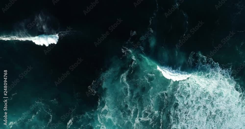 Top down aerial view of giant ocean waves crashing and foaming