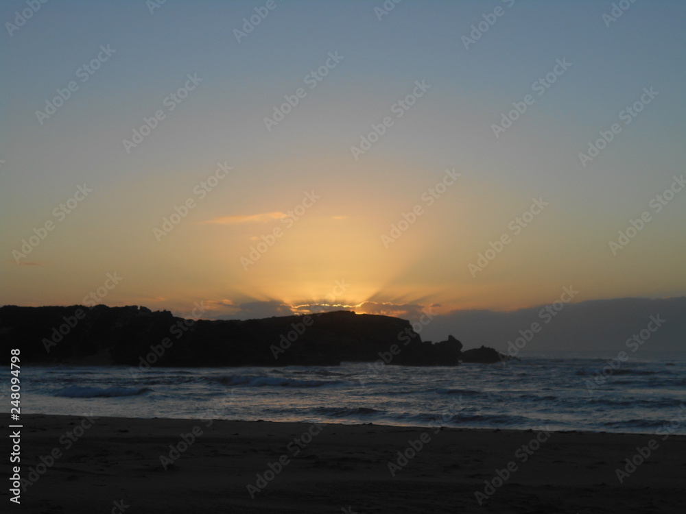 Sun rise over rocks & sea