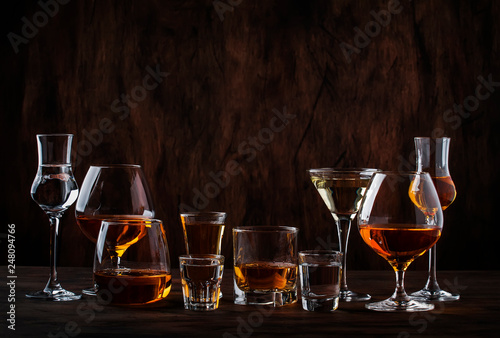 Selection of hard strong alcoholic drinks in big glasses and small shot glass in assortent: vodka, cognac, tequila, brandy and whiskey, grappa, liqueur, vermouth, tincture, rum. 