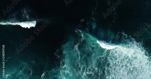 Top down aerial view of giant ocean waves crashing and foaming