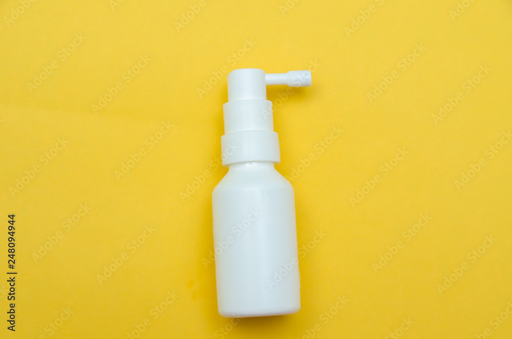 white bottle spray on a yellow background, spray from the cold white bottle spray on a yellow background, spray from the cold