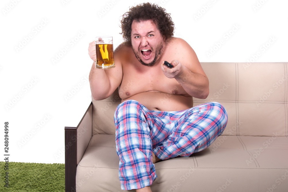 Fototapeta premium Funny fat man watching tv at home.