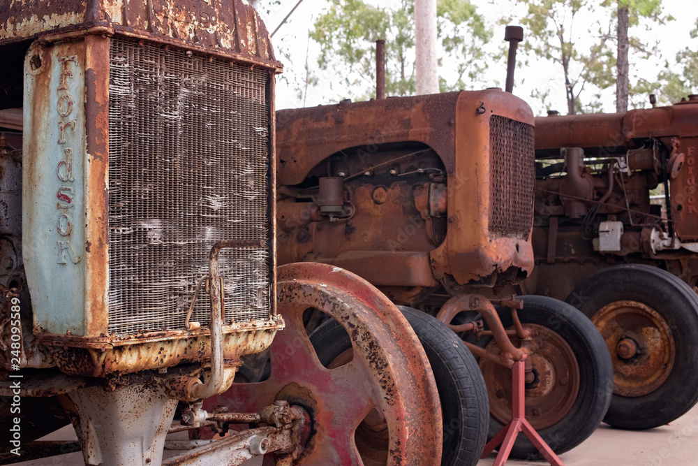 Old rusted tractor, three in a row, collection of antique farm equipment