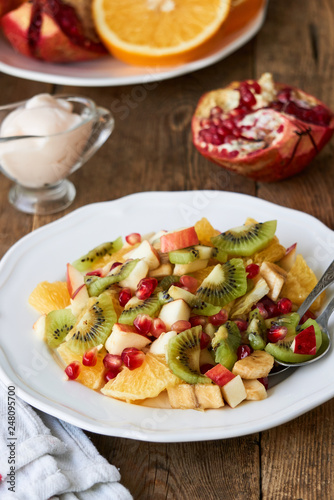 Salad with various fresh fruits on a white plate 