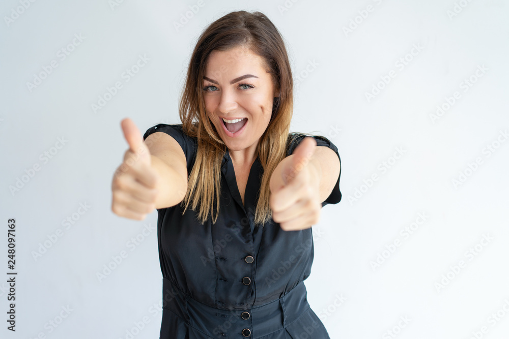 Excited lady showing thumbs up and looking at camera Excited lady showing thumbs up and looking at camera