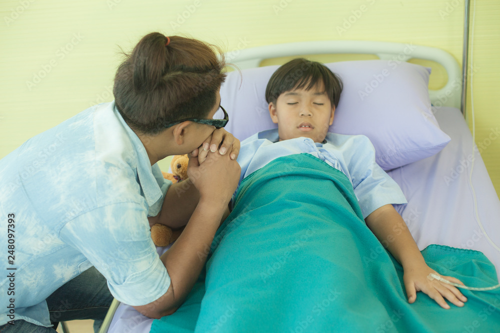 One father is holding his hand. And encouraging the son who is seriously ill And rest In bed in a hospital - healthcare concept image One father is holding his hand. And encouraging the son who is seriously ill And rest In bed in a hospital - healthcare concept image