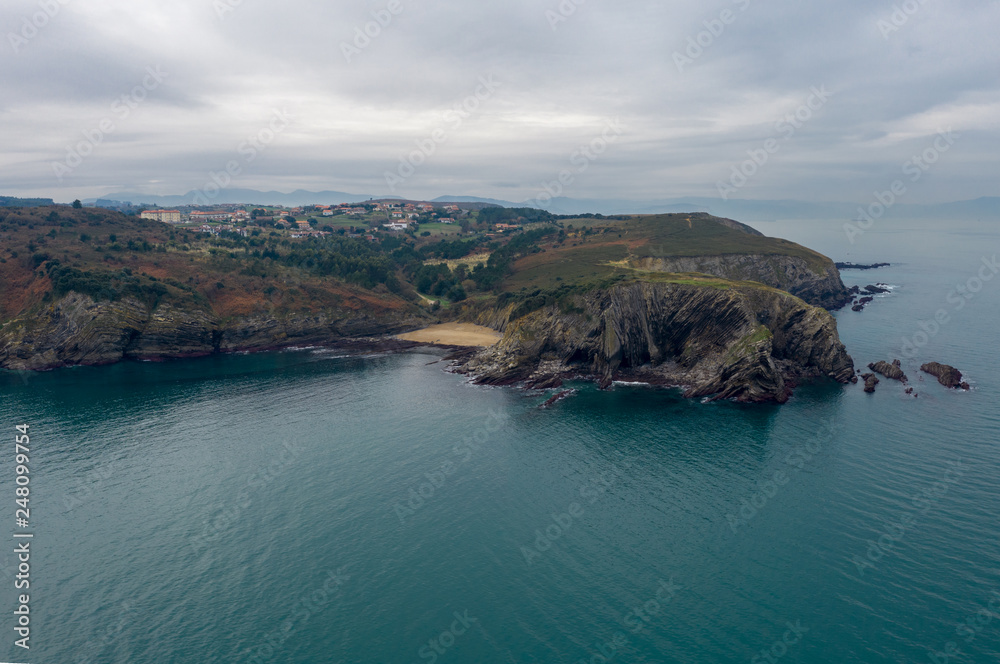 Aerial; panoramic drone view of Plenzia resort city, Bilbao agglomeration; winter monotonous beauty of Atlantic ocean beaches; steep stone slopes and flysches; cloudy day on desert coastline of Basque Aerial; panoramic drone view of Plenzia resort city, Bilbao agglomeration; winter monotonous beauty of Atlantic ocean beaches; steep stone slopes and flysches; cloudy day on desert coastline of Basque