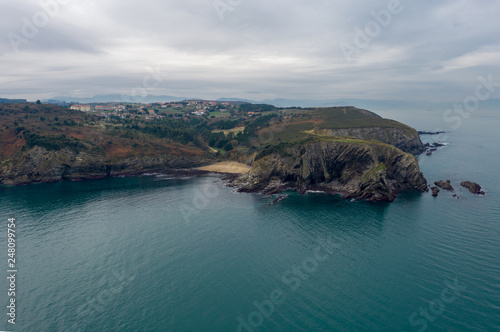 Aerial  panoramic drone view of Plenzia resort city  Bilbao agglomeration  winter monotonous beauty of Atlantic ocean beaches  steep stone slopes and flysches  cloudy day on desert coastline of Basque
