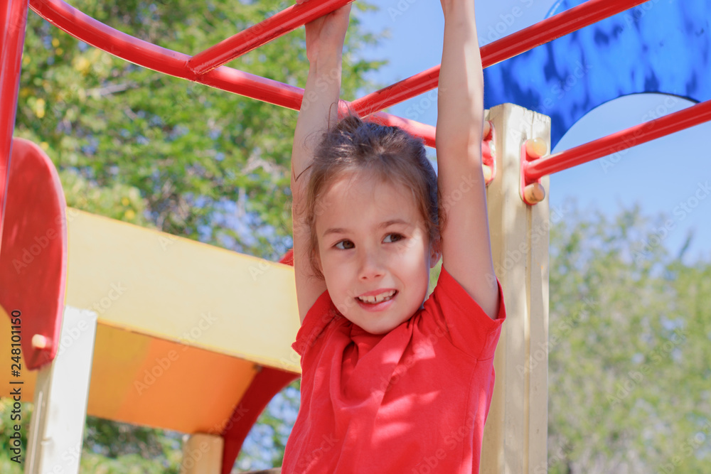 A girl climbs the stairs on the playground in the park A girl climbs the stairs on the playground in the park