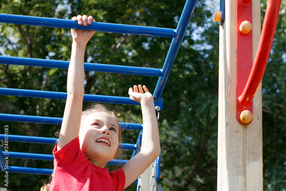 A girl climbs the stairs on the playground in the park A girl climbs the stairs on the playground in the park