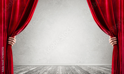 Concrete wall behind drapery curtain and hand opening it