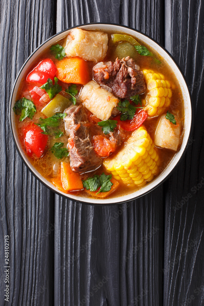 Sancocho is a meats and vegetables stew, enjoyed in Latin America and the Spanish Caribbean islands close-up on a bowl. Vertical top view Sancocho is a meats and vegetables stew, enjoyed in Latin America and the Spanish Caribbean islands close-up on a bowl. Vertical top view