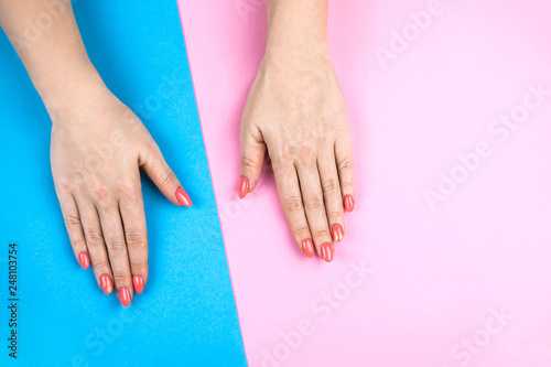 Lovely young woman s hands on colored background.