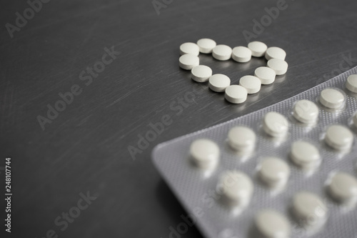 Heart-shaped pills on the medical table close-up photo
