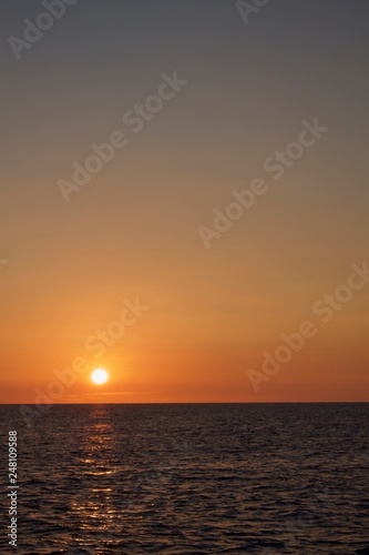 Looking out at the ocean with the sun low on the horizon at sunset. © Jordan