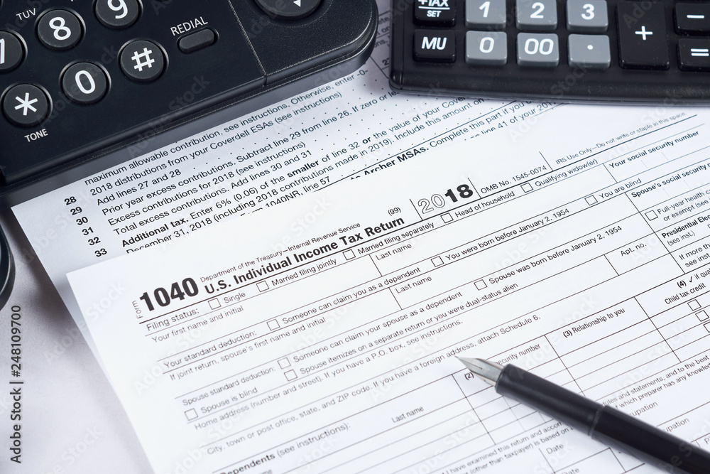 Tax reporting. 1040 tax form, pen, phone and calculator on light background Tax reporting. 1040 tax form, pen, phone and calculator on light background