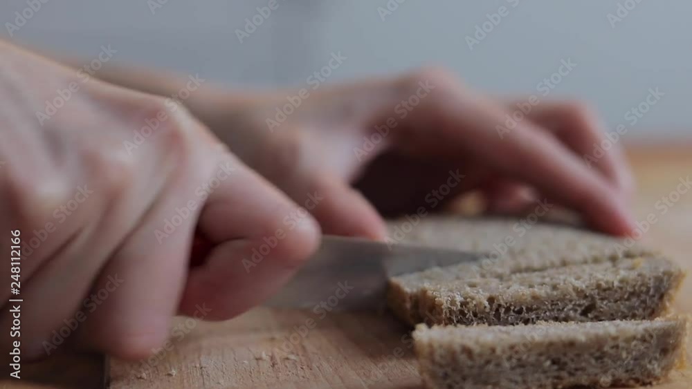 Woman slicing cereals breads on wooden board Woman slicing cereals breads on wooden board
