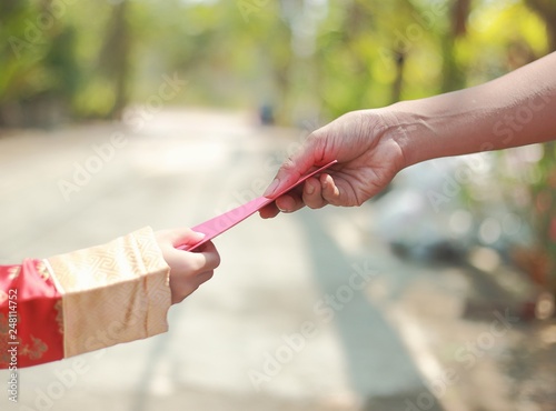 Chinese new year - hand giving red envelop with money to boy