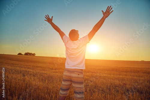 Man with arms wide open in nature.