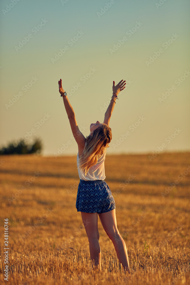 Cute young woman jumping in a wheat field. Cute young woman jumping in a wheat field.