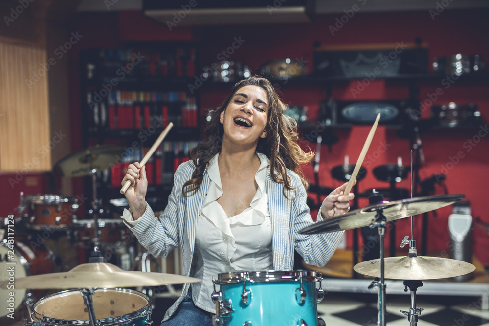 Fototapeta premium Young girl enjoys a musical instrument store