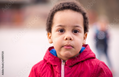 portrait of a cute boy looking at a camera with sad or questioning look on his face