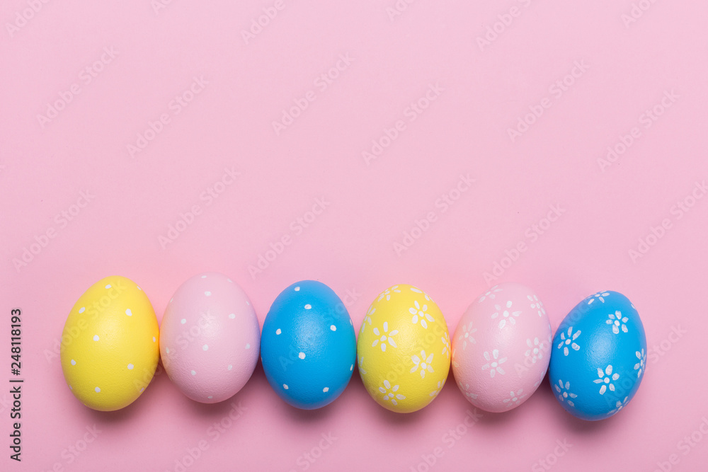 Colorfull easter eggs in nest on pastel color background with space. Concept