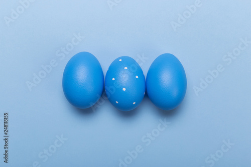 Colorful easter eggs in nest on pastel color background with space.