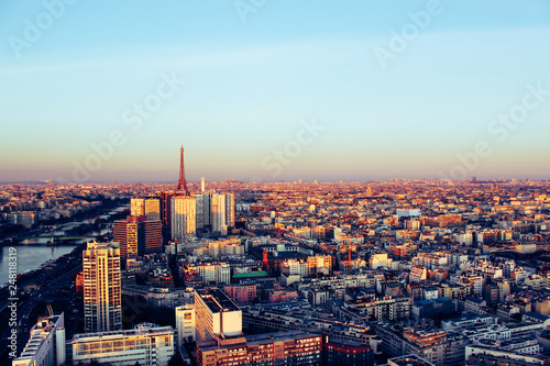 Eiffel tower between buildings in the last rays of the sun. Aerial view of Paris  France