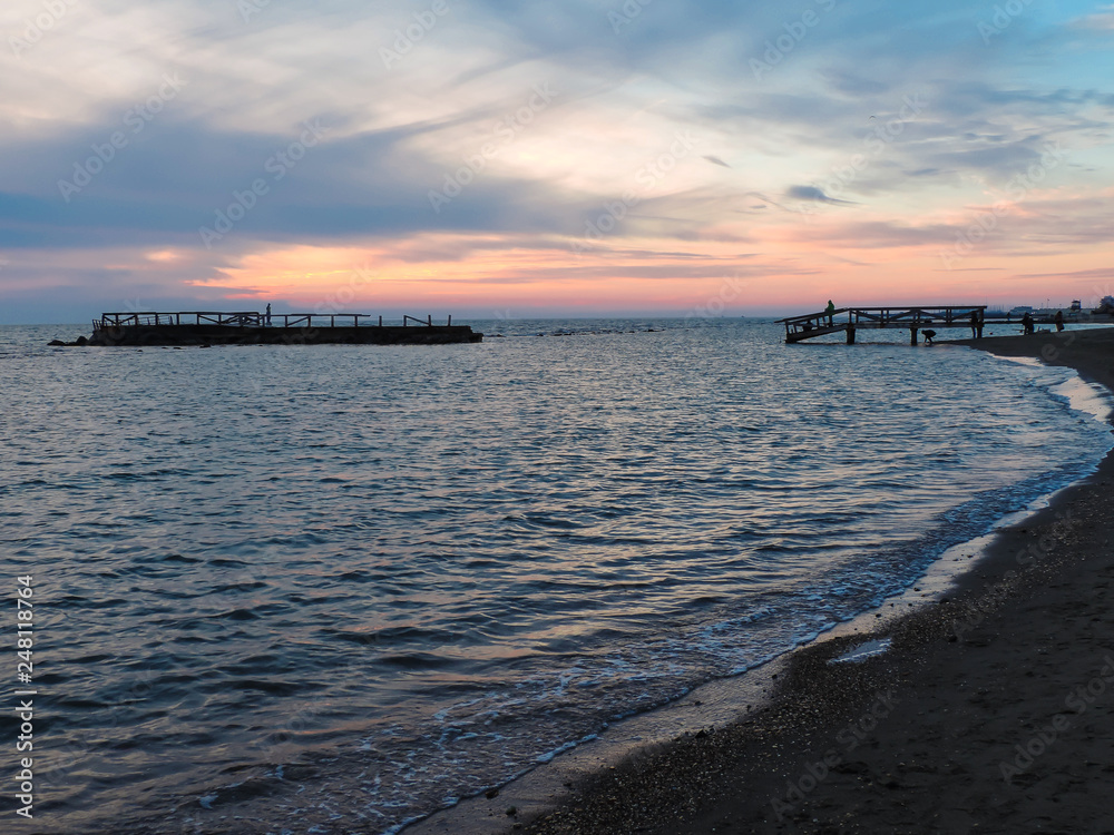 Clouds at sunset above the pier and blue sea, Ostia, Rome, Italy Clouds at sunset above the pier and blue sea, Ostia, Rome, Italy