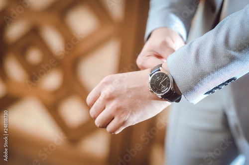 Dressed Man putting his wrist watch 