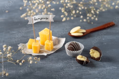 Dark Chocolate candies with cheese and parmisan on the background. photo