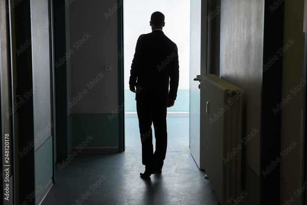 Businessman Standing In Front Of Open Door