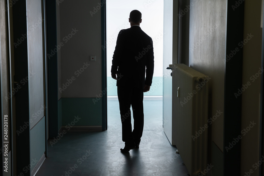Fototapeta premium Businessman Standing In Front Of Open Door